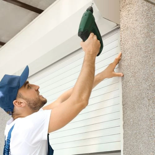 Técnico a reparar estores